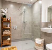 Modern bathroom with a glass-enclosed shower, wooden shelf with towels and toiletries, a sink, and a toilet.